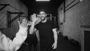 A group of athletes celebrating post-workout with a high-five, highlighting community, motivation, and consistency in training and nutrition.