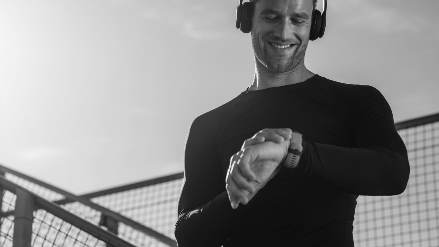 A fit athlete tracks his workout performance using a smartwatch, highlighting the role of exercise in smoking cessation and cardiovascular improvement.