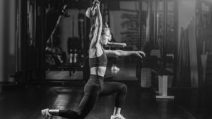 A female athlete executing a kettlebell snatch in a gym, showcasing advanced kettlebell training and explosive power development.