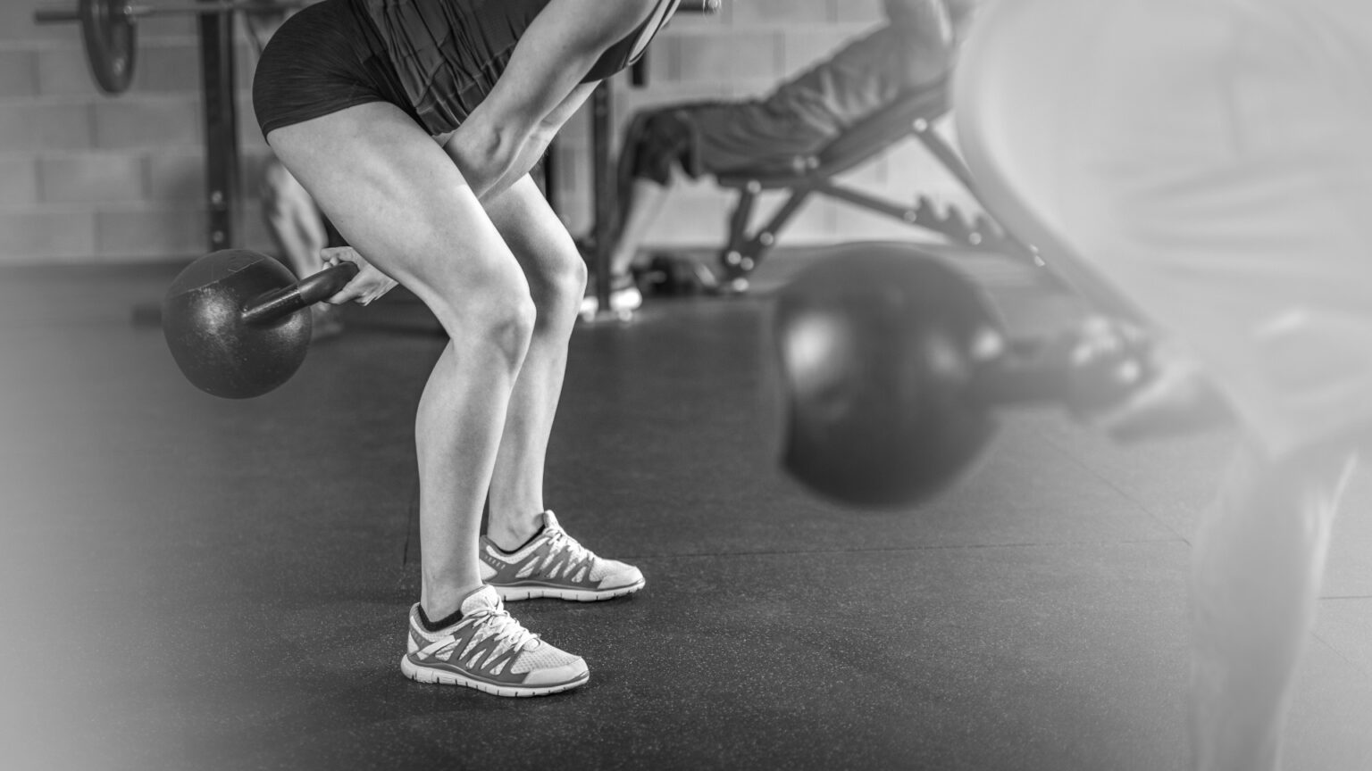 Close-up of a kettlebell swing in motion, emphasizing proper hip hinge mechanics and grip strength during training.