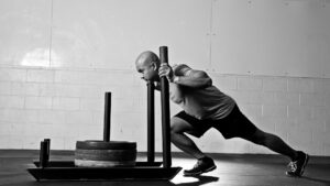 Athlete pushing a weighted sled during a sprint training session.