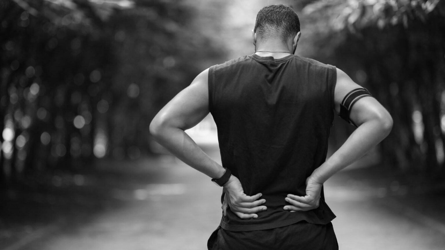 Runner holding lumbar area—reminder that smart back workouts prevent post-run lower-back pain
